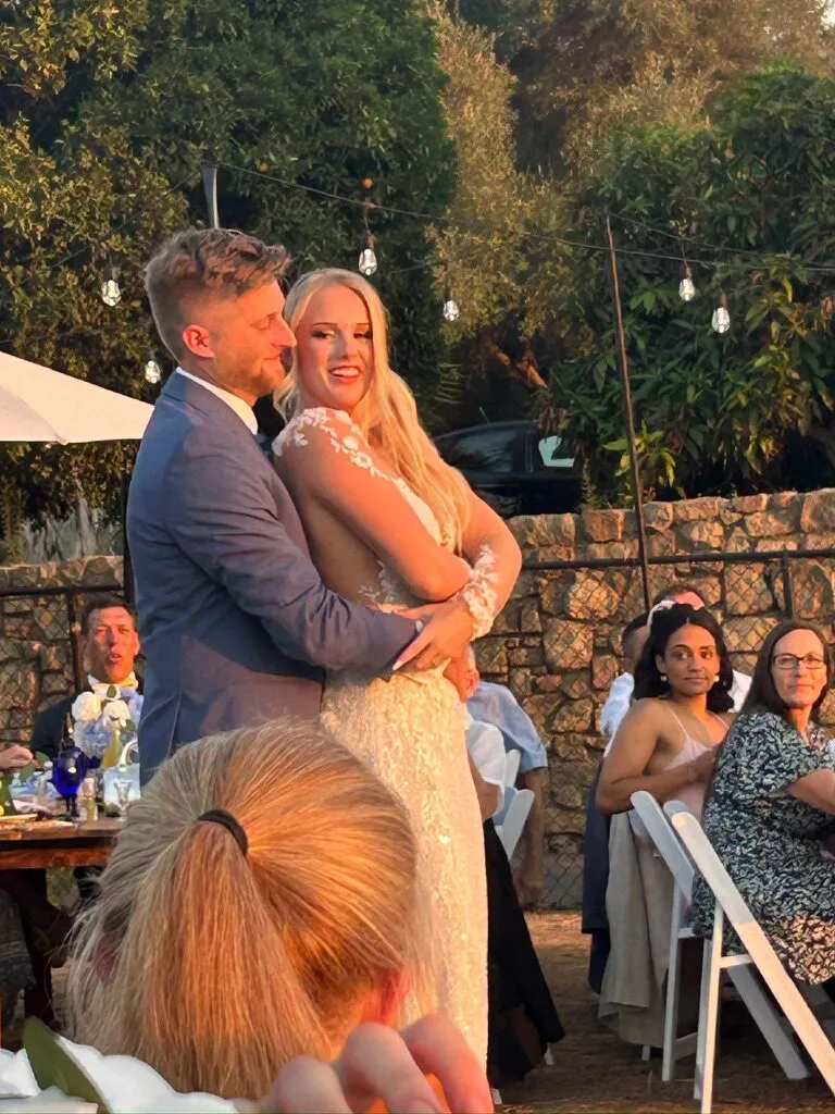 Bride and groom embracing at the reception under string lights