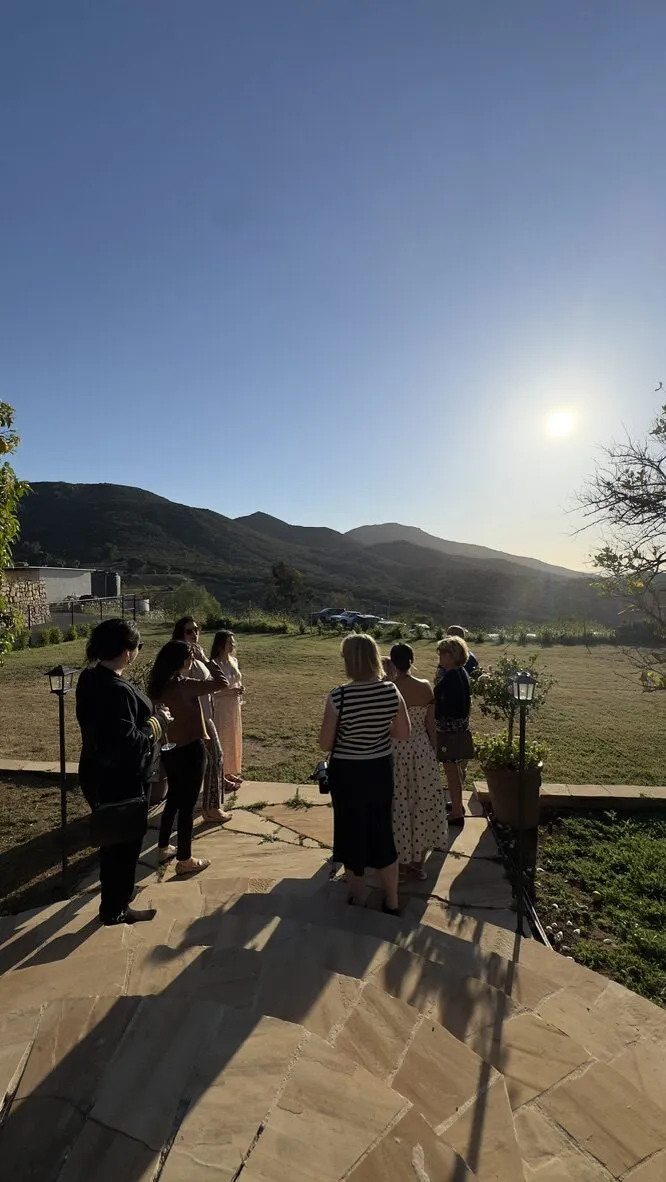 Guests at golden hour on the terrace with the hills glowing behind