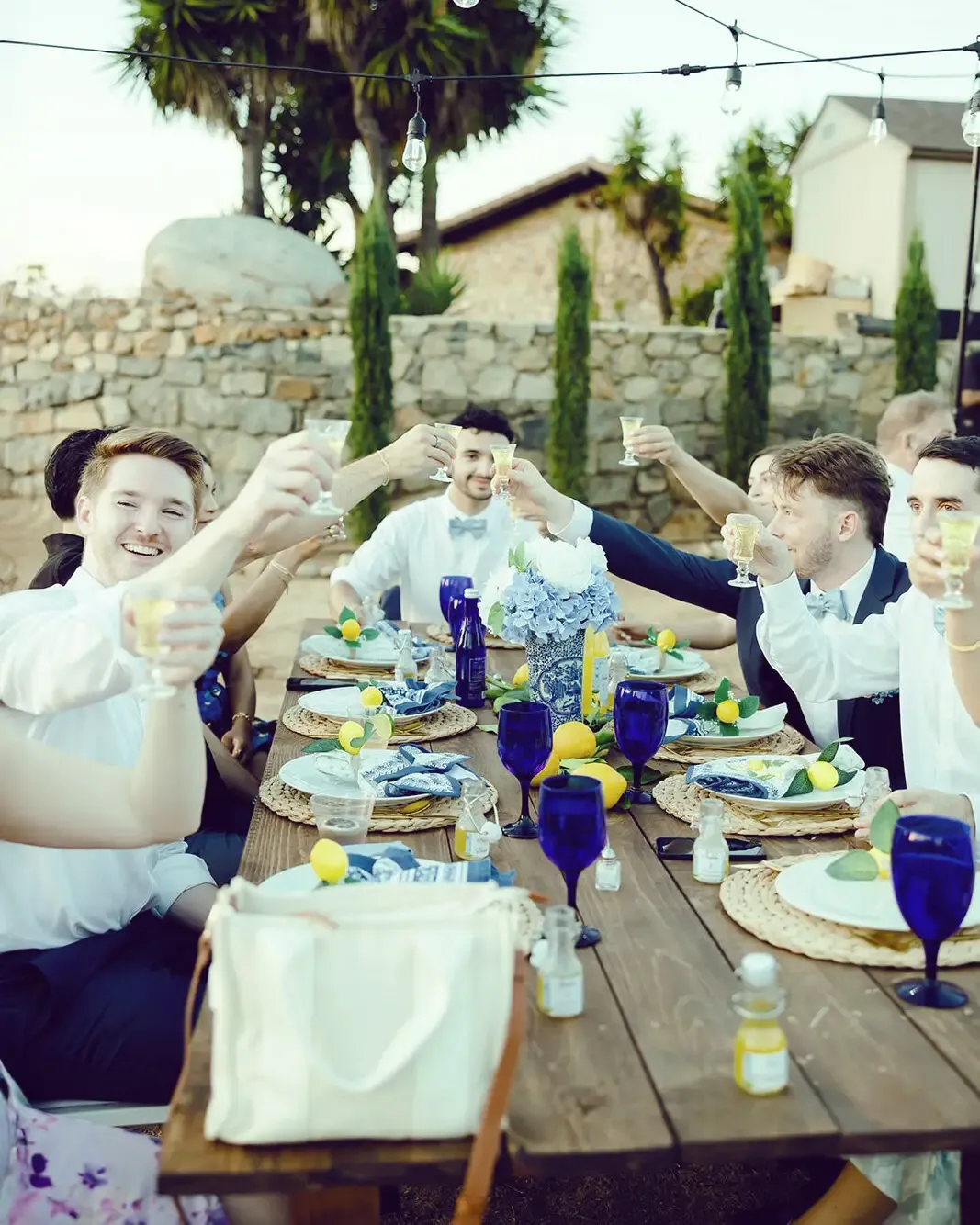 Wedding guests raising limoncello glasses in a toast at a long table at Villa San Giovese