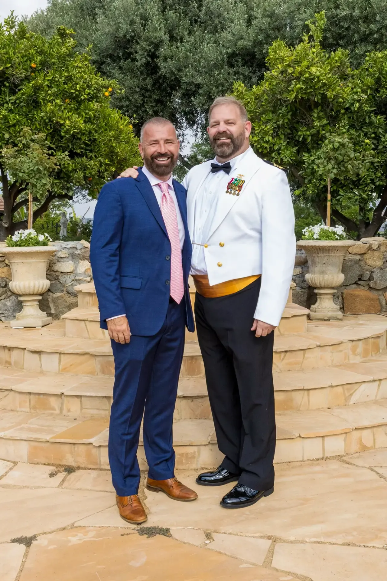 Todd and Bruno, the owners of Villa San Giovese, dressed formally on the garden steps of the estate