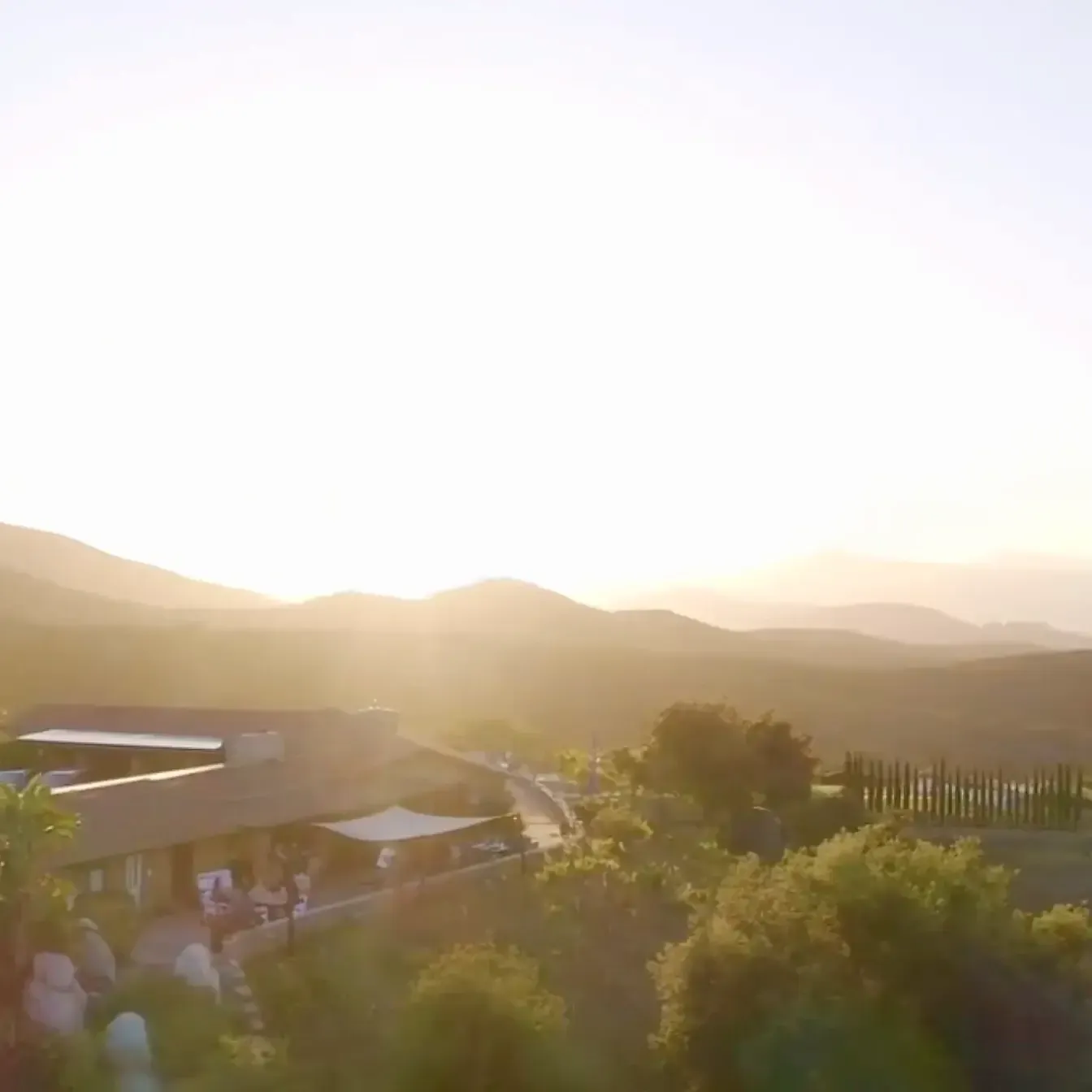 The villa and grounds of Villa San Giovese glowing at sunset with layered Jamul mountain ridges behind
